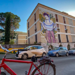 Vélo rouge devant une fresque à Ostiense à Rome