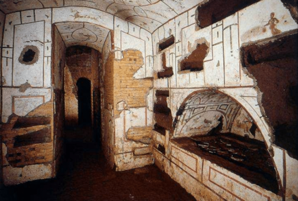 Intérieur des catacombes de Priscille. On voit une niche creusée à droite et un couloir en face.