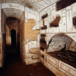 Intérieur des catacombes de Priscille. On voit une niche creusée à droite et un couloir en face.