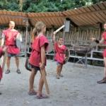 5 personnes habillées en tenue de gladiateurs en train de jouer aux gladiateurs dans une petite arène