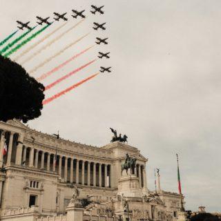 Avions survolant le Monument Victor Emmanuel II en laissant des fumées vertes blanches et rouges.