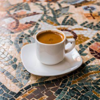 Petite tasse de café posée sur une soucoupe sur une table en mosaïque